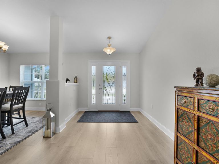 A welcoming entryway in a Palm Coast home featuring elegant glass doors leading to the dining and living rooms.