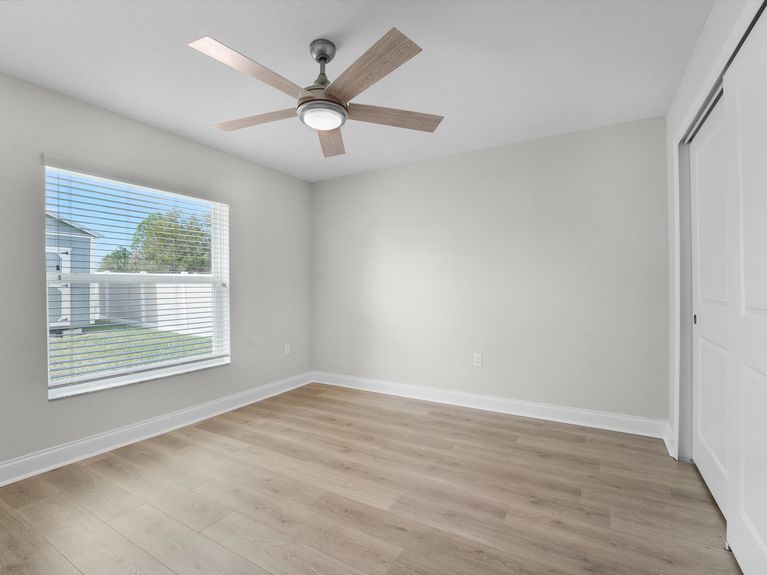 A cozy guest bedroom in a Palm Coast home featuring a comfortable bed, soft lighting, and warm, neutral decor.