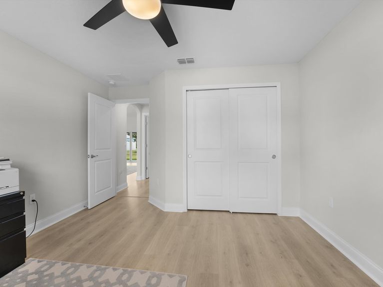 A cozy guest bedroom in a Palm Coast home featuring a comfortable bed, soft lighting, and warm, neutral decor.