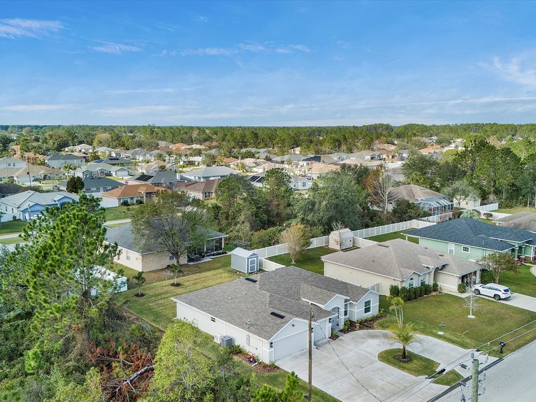 A quiet and picturesque neighborhood in Palm Coast, Florida, featuring tree-lined streets, well-maintained homes, and spacious lots with no HOA or CDD fees.