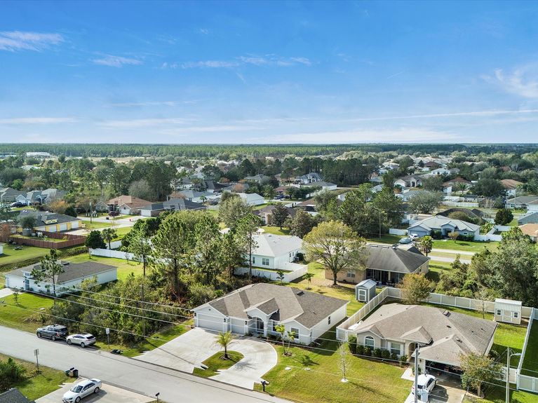 A scenic view of Hammock Beach in Palm Coast, Florida, featuring white sand, gentle waves, and a vibrant blue sky.