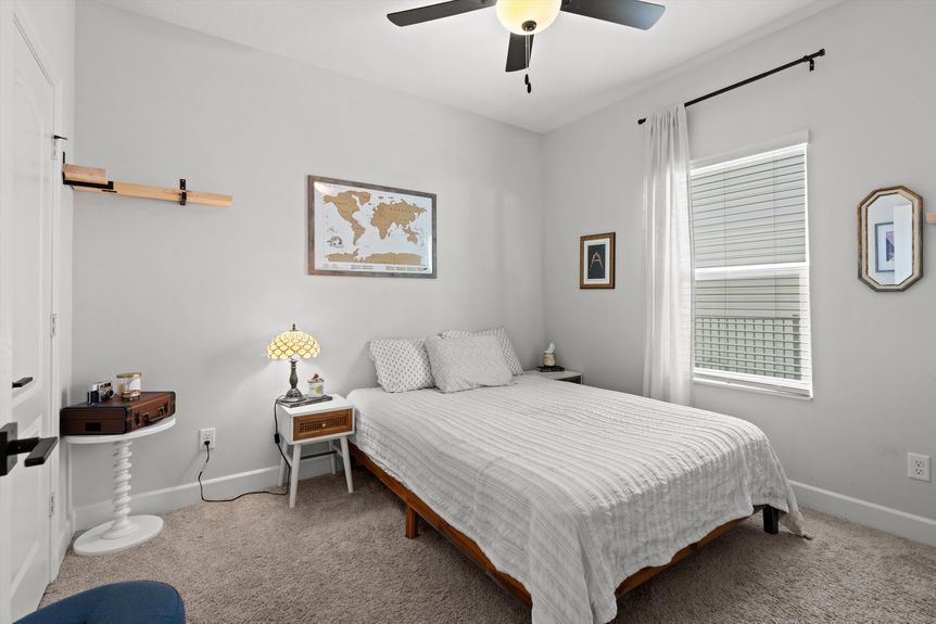 Spacious bedroom with large windows, soft lighting, and a cozy ambiance.