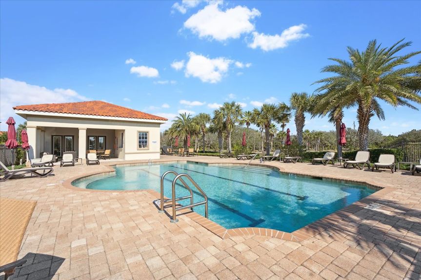 Community pool at The Estuaries in St. Augustine, FL, surrounded by lush tropical landscaping.