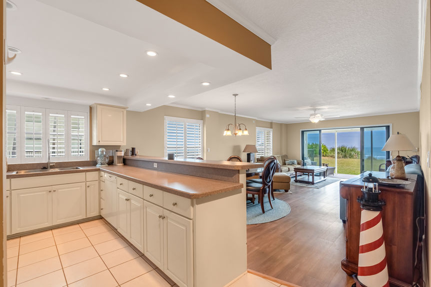 Kitchen & Dining Area – Bright kitchen with lots of counter space, large area for barstool seating, and a dining area overlooking the ocean.