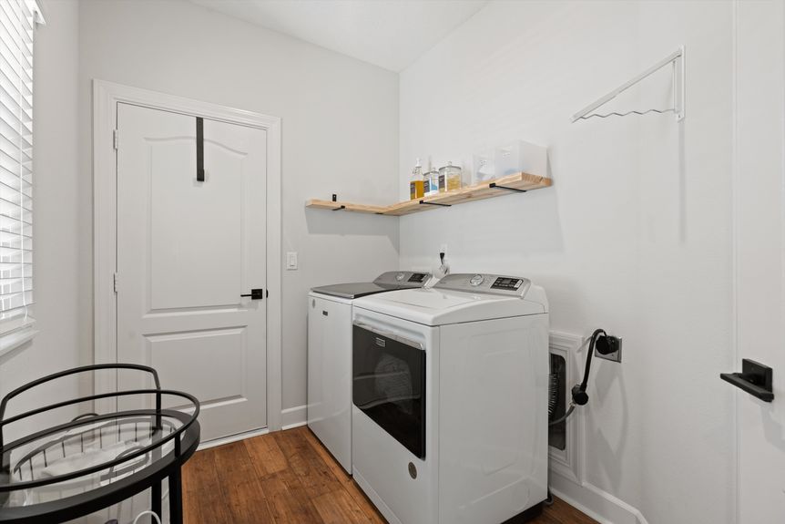 Functional laundry room with cabinets, counter space, and modern appliances in a St. Augustine home.
