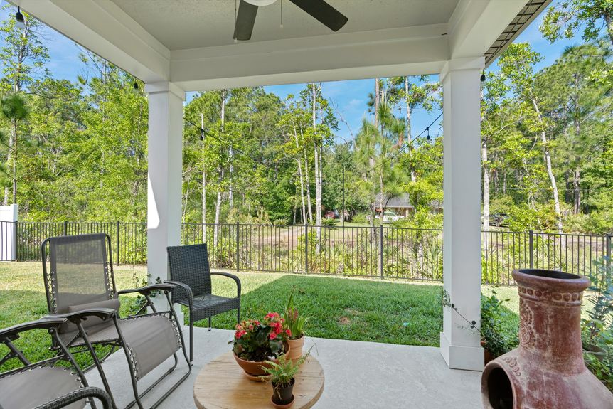 Covered patio with seating area overlooking a backyard in a St. Augustine home.