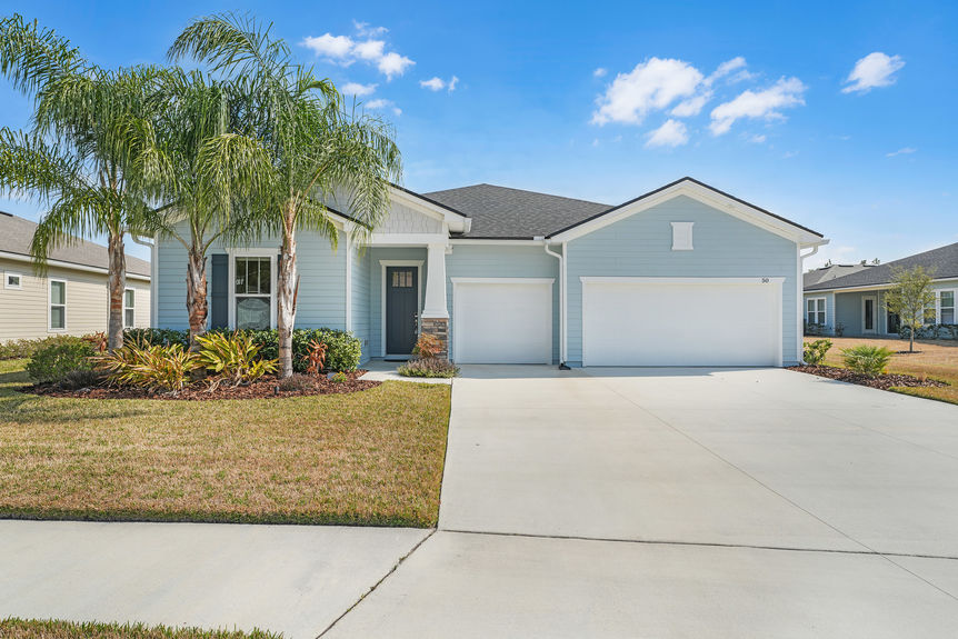Beautiful one-story home at 50 Skyline Lane in St. Augustine’s 55+ community, featuring a well-manicured lawn, inviting front porch, and modern architectural design.