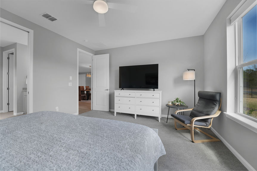 Bright and airy guest bedroom with neutral tones, large windows, and a private ensuite bath at 50 Skyline Lane.