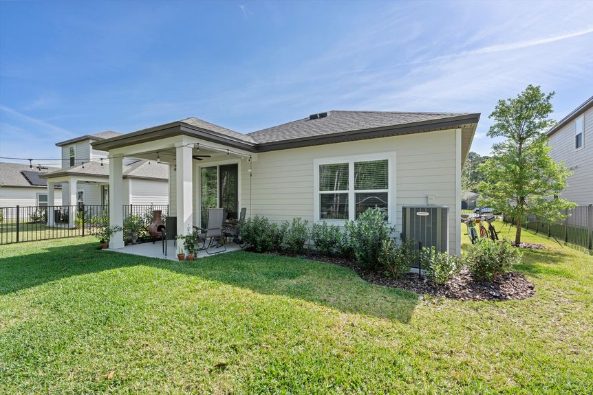 Spacious backyard with a well-maintained lawn, privacy fencing, and mature landscaping.