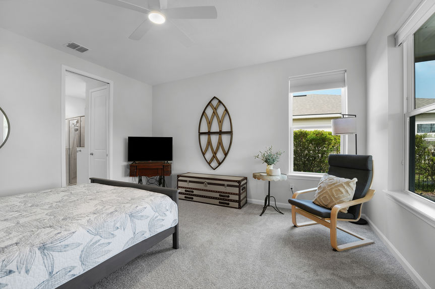 Bright and airy guest bedroom with neutral tones, large windows, and a private ensuite bath at 50 Skyline Lane.