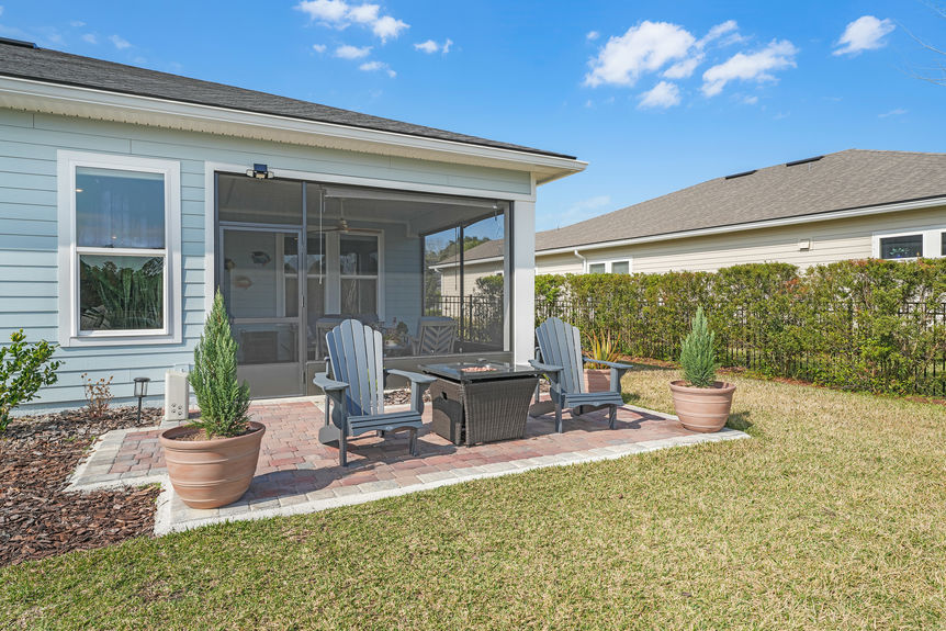 Spacious covered patio with seating area and a beautiful backyard view at 50 Skyline Lane.