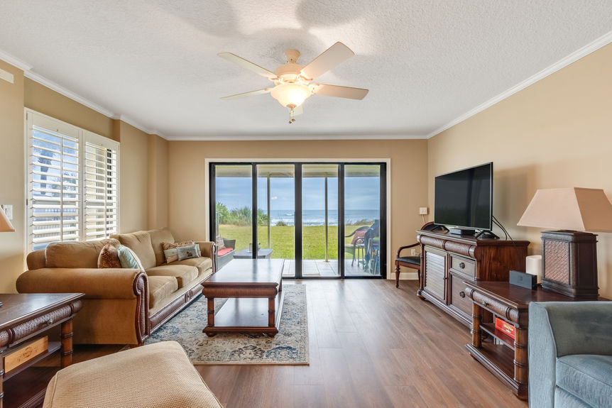 Living Room View – Spacious oceanfront living room with floor-to-ceiling windows and a stunning view of St. Augustine Beach.