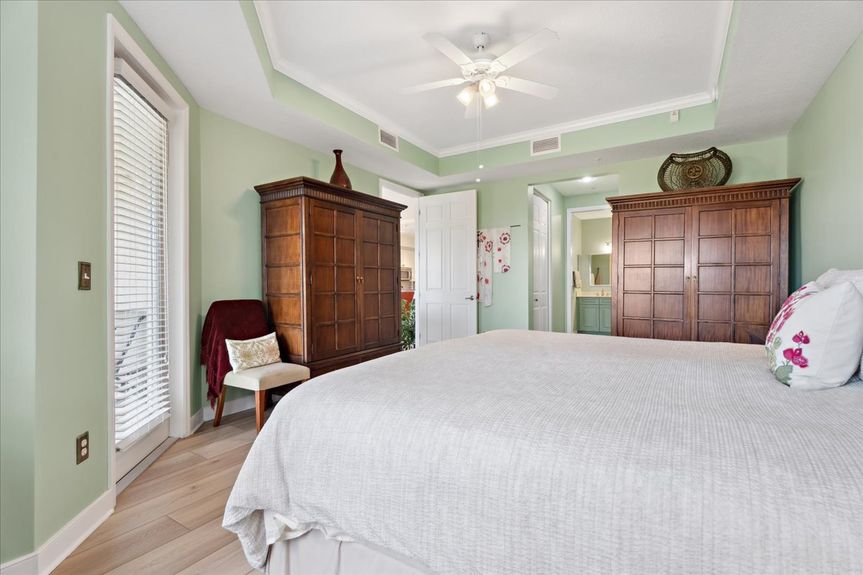 Master bedroom in a St. Augustine condo, showcasing expansive windows with picturesque marsh views.