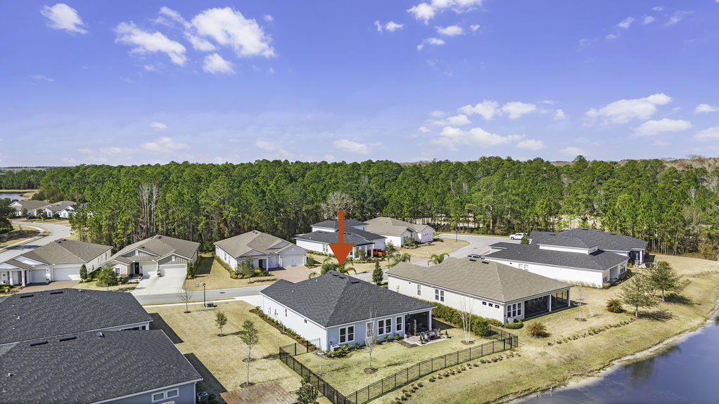 Aerial perspective of the backyard at 50 Skyline Lane, featuring a covered patio, green space, and peaceful surroundings in St. Augustine’s Reverie at Trailmark.