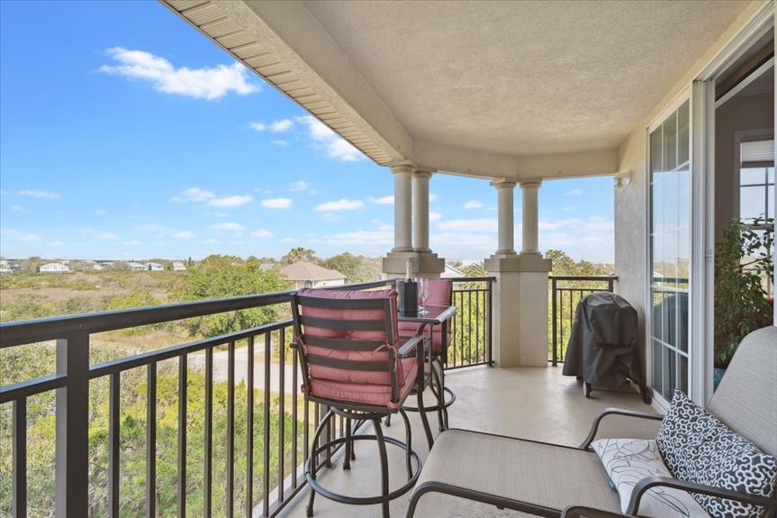 Spacious living room with natural light, modern decor, and a sliding glass door leading to a private balcony at 170 Pantano Cay Blvd #4305, St. Augustine.