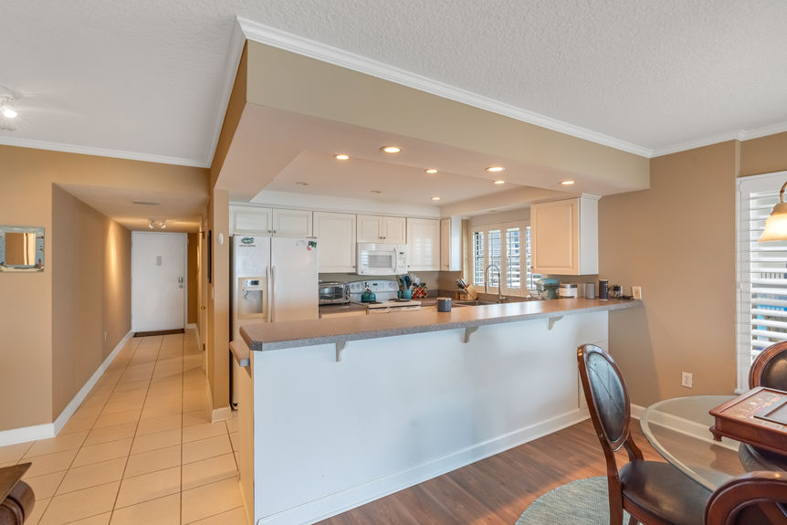 Kitchen & Dining Area – Bright kitchen with lots of counter space, large area for barstool seating, and a dining area overlooking the ocean.
