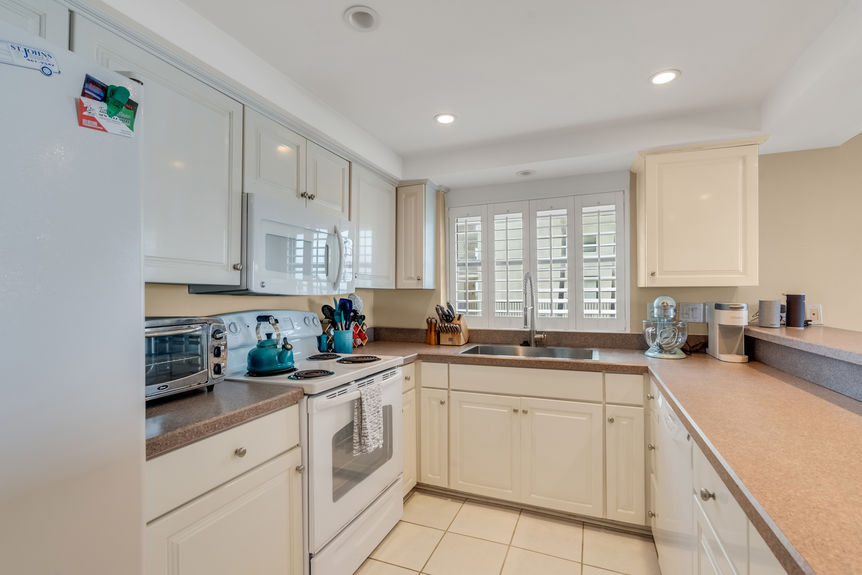 Kitchen & Dining Area – Bright kitchen with lots of counter space, large area for barstool seating, and a dining area overlooking the ocean.