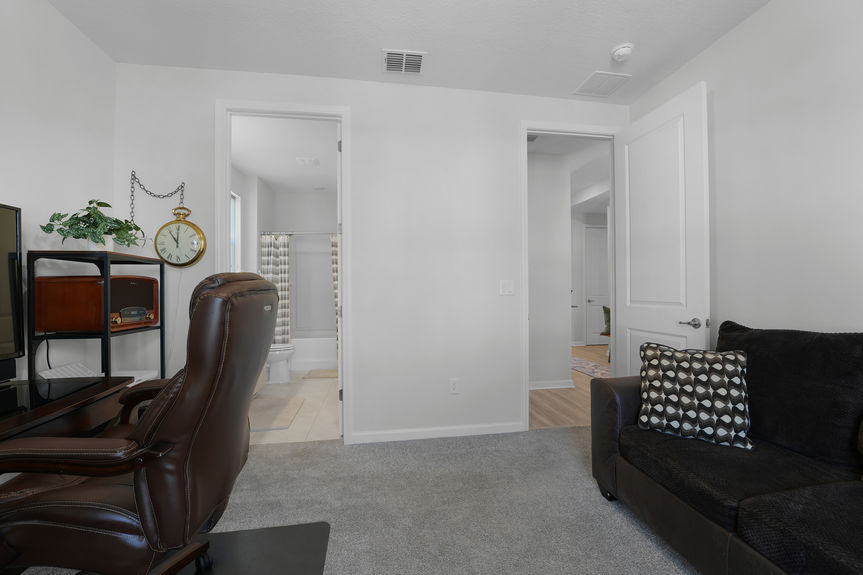 Bright and airy guest bedroom with neutral tones, large windows, and a private ensuite bath at 50 Skyline Lane.