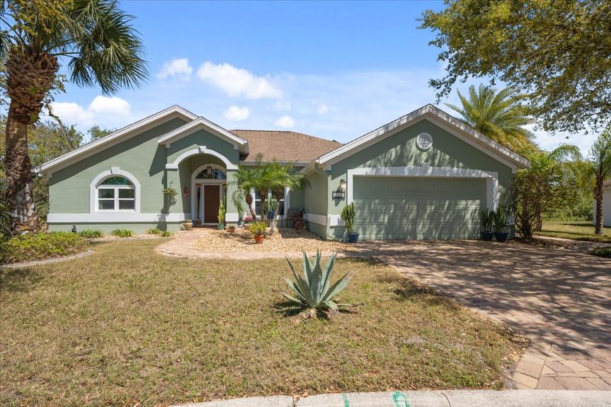 Front view of a beautifully maintained 3-bedroom home at 192 Anastasia Lakes Drive, featuring a paved driveway, manicured landscaping, and a peaceful cul-de-sac setting.