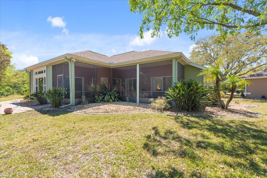 Large screened-in lanai at 192 Anastasia Lakes Drive, offering peaceful marsh views, ample seating space, and a relaxing outdoor retreat.
