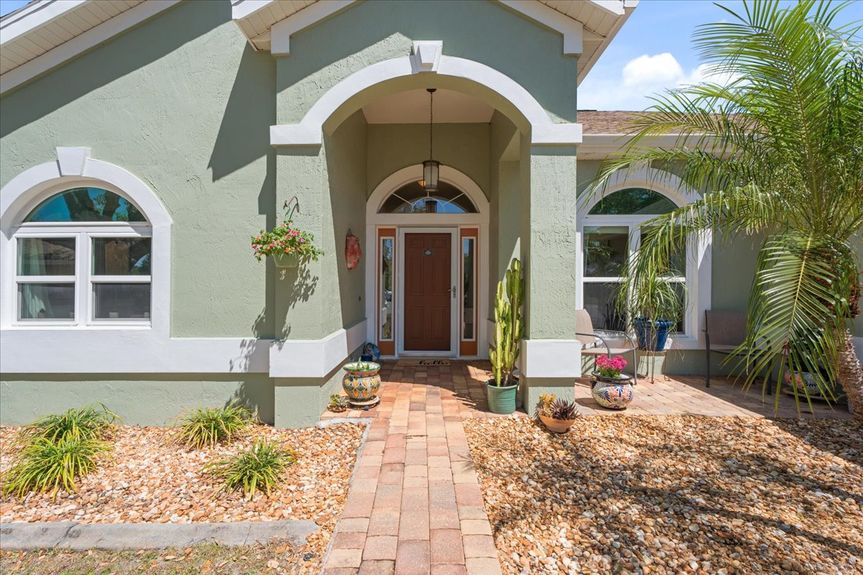 Front view of a beautifully maintained 3-bedroom home at 192 Anastasia Lakes Drive, featuring a paved driveway, manicured landscaping, and a peaceful cul-de-sac setting.