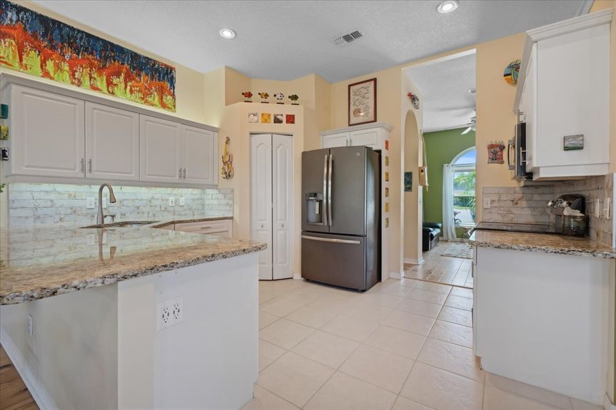 Expansive kitchen featuring granite countertops, under-cabinet LED lighting, and stainless steel appliances for a sleek and functional design.