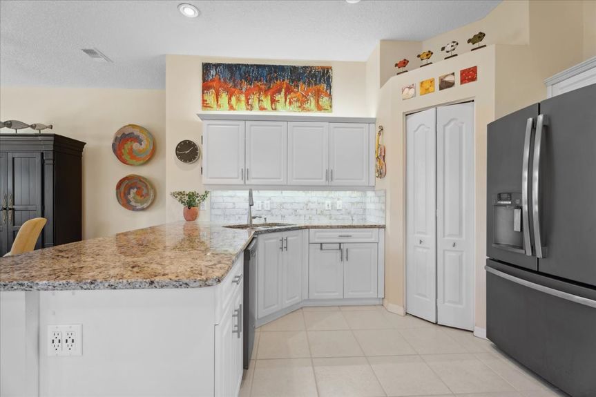Expansive kitchen featuring granite countertops, under-cabinet LED lighting, and stainless steel appliances for a sleek and functional design.