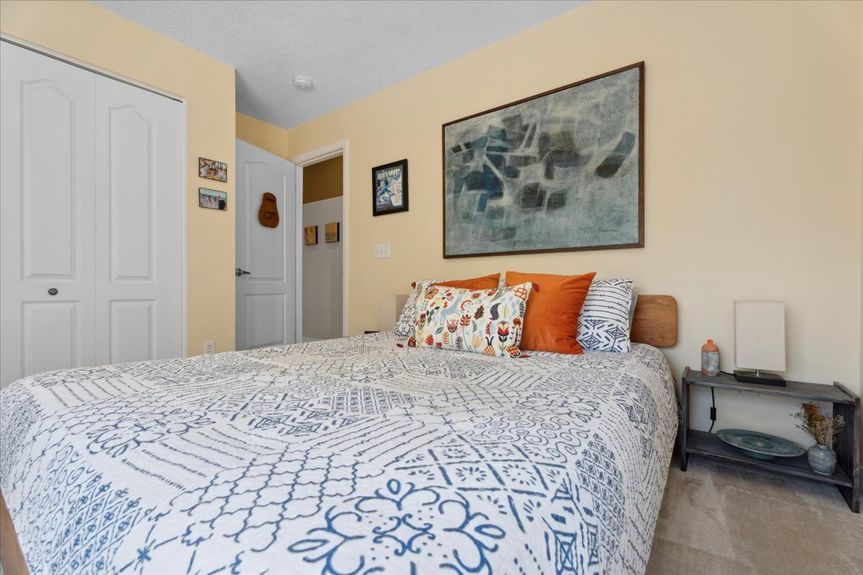 Comfortable guest bedroom at 192 Anastasia Lakes Drive, featuring soft natural light, plush carpeting, and a tranquil atmosphere.