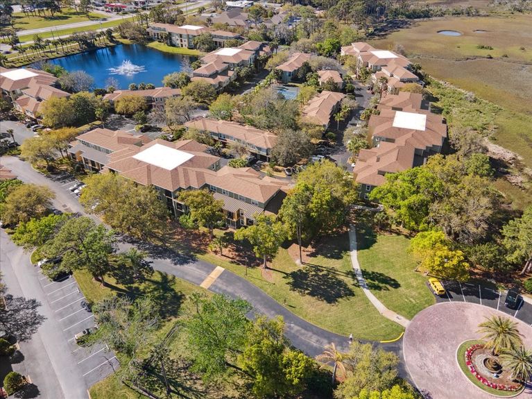 Aerial view of 4000 Grande Vista Blvd Unit 15-104 in the Las Palmas community, showcasing the condo building and peaceful marsh surroundings.