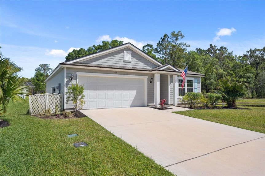 Front view of a single-story move-in ready home with 3 bedrooms, 2 baths, screened lanai, and pond views near community pool, pickleball courts, and fitness center.