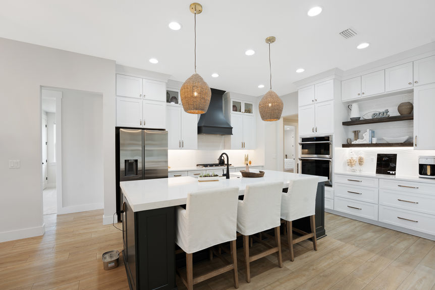 Spacious kitchen featuring quartz countertops, stainless steel appliances, and a large island with seating