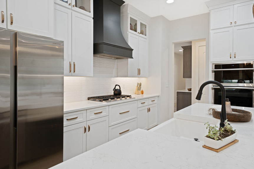 Spacious kitchen featuring quartz countertops, stainless steel appliances, and a large island with seating