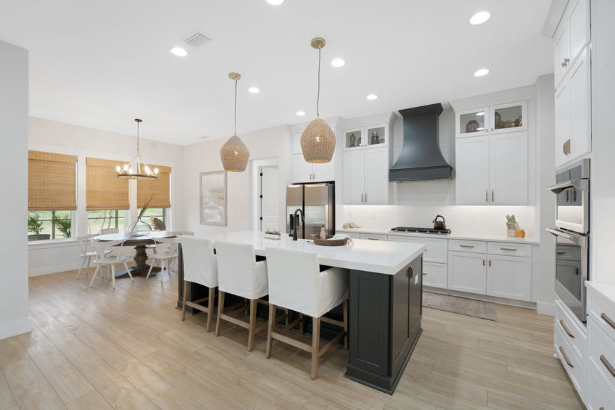 Spacious kitchen featuring quartz countertops, stainless steel appliances, and a large island with seating