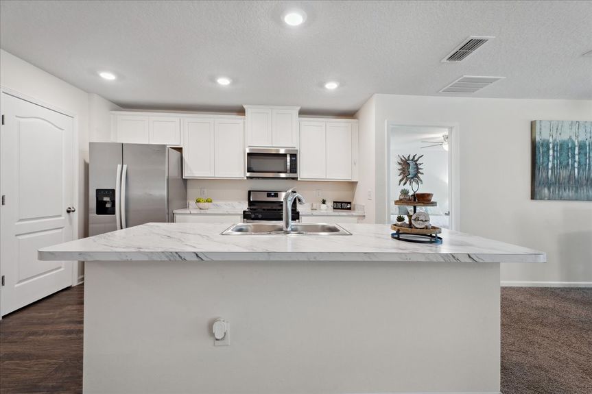 Single-story move-in ready home with 3 bedrooms, 2 baths, screened lanai, and pond views near community pool, pickleball courts, and fitness center.