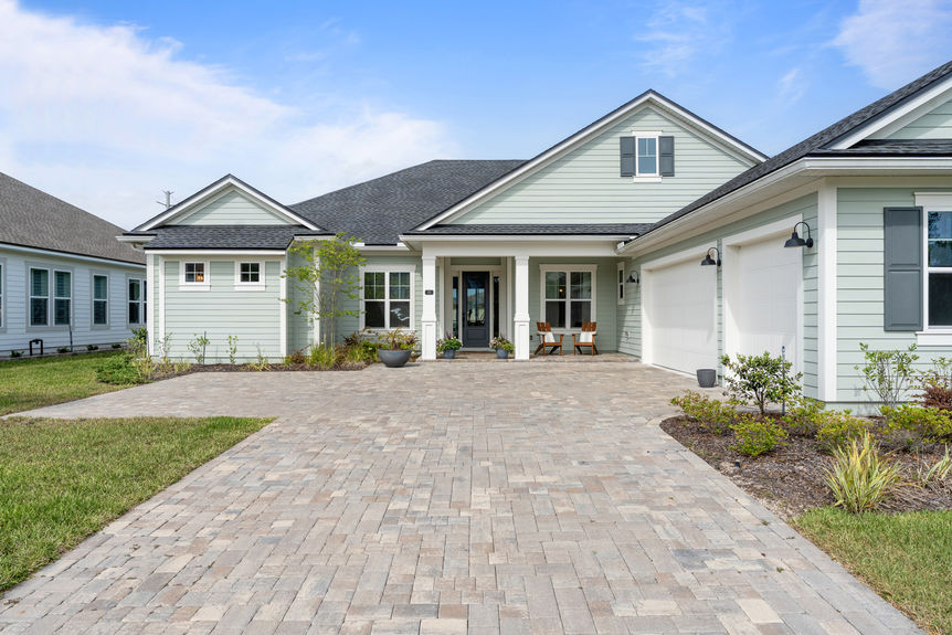 Front exterior of a modern single-family home at 22 Red Twig Way, featuring a manicured lawn and three-car garage
