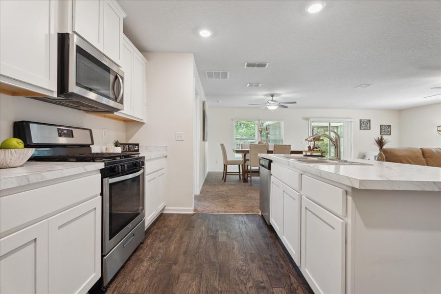 Single-story move-in ready home with 3 bedrooms, 2 baths, screened lanai, and pond views near community pool, pickleball courts, and fitness center.