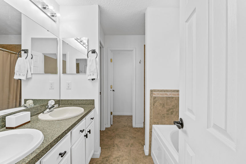 Bathroom with sleek vanity, neutral finishes, and natural light in St. Augustine pool home
