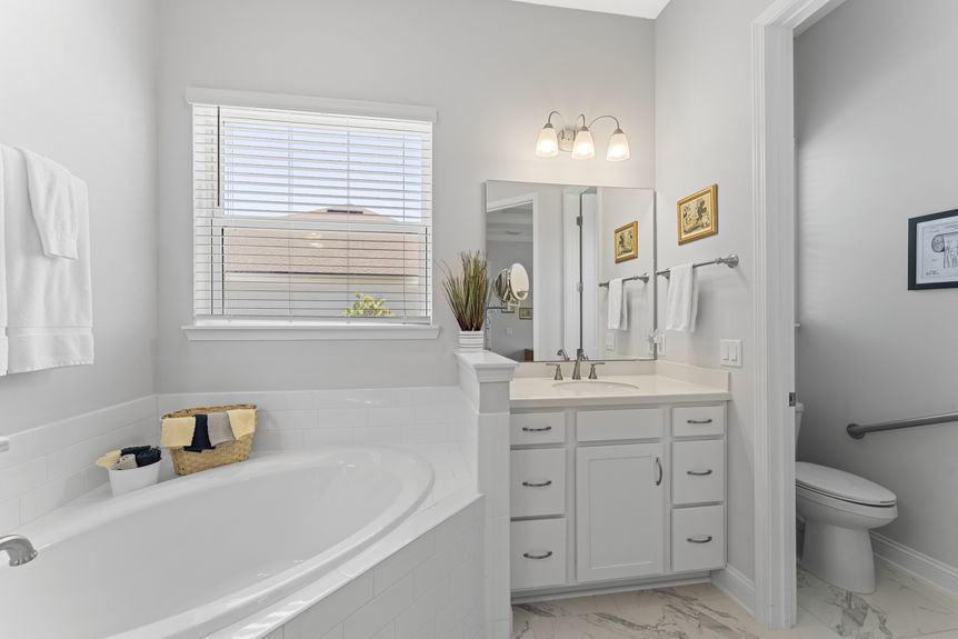 Primary bathroom featuring soaking tub, walk-in shower, and dual vanities in Madeira home
