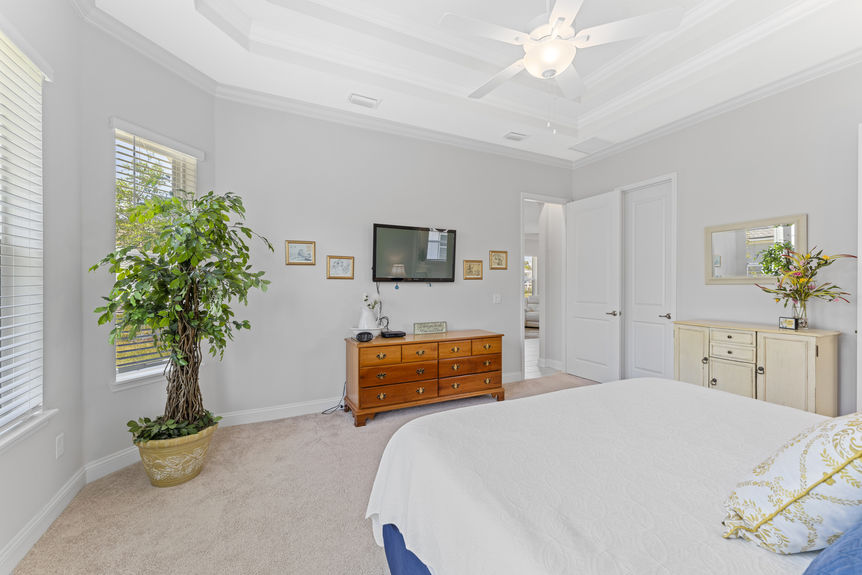 Primary bedroom with large windows and ensuite bathroom in Madeira home