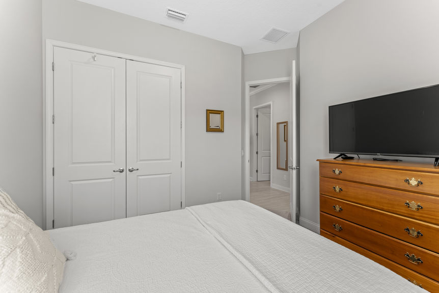 Bright and airy guest bedroom with large window and neutral tones in Madeira home