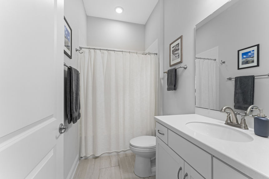 Guest bathroom with single vanity, combination tub and shower, and modern finishes