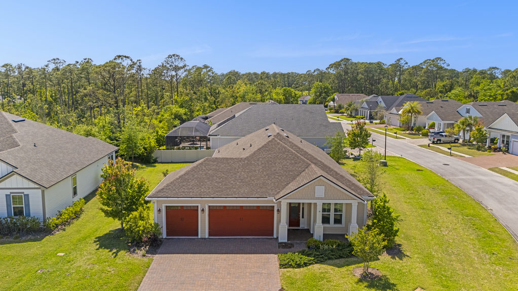 Aerial view showcasing the home’s roofline, 3-car garage, corner lot placement