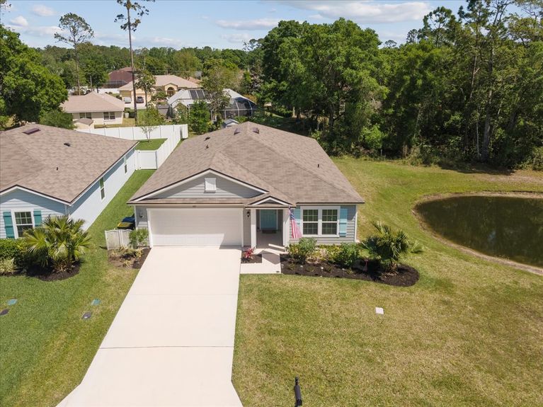Aerial front view of a single-story move-in ready home with 3 bedrooms, 2 baths, screened lanai, and pond views near community pool, pickleball courts, and fitness center.