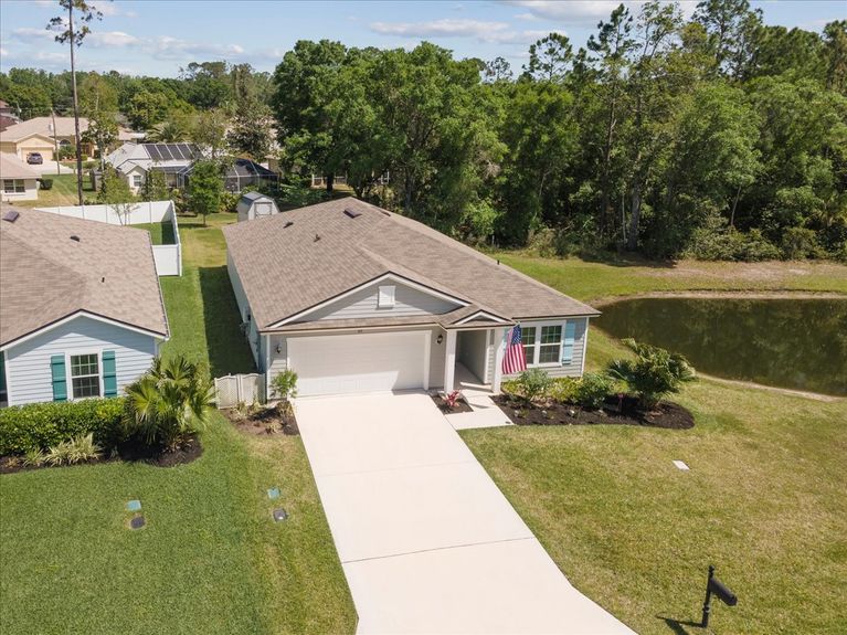 Aerial front view of a single-story move-in ready home with 3 bedrooms, 2 baths, screened lanai, and pond views near community pool, pickleball courts, and fitness center.