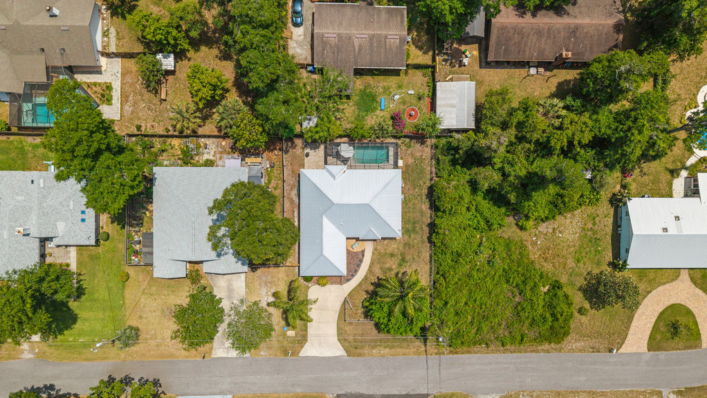 Overhead aerial view of St. Augustine South 4-bedroom pool home with fenced yard, screened lanai, metal roof, guest suite, and space for RV or boat—no HOA.