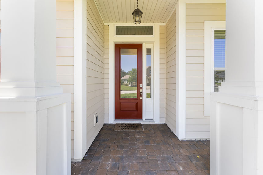 Covered front porch with decorative columns and inviting entry door in St. Augustine home