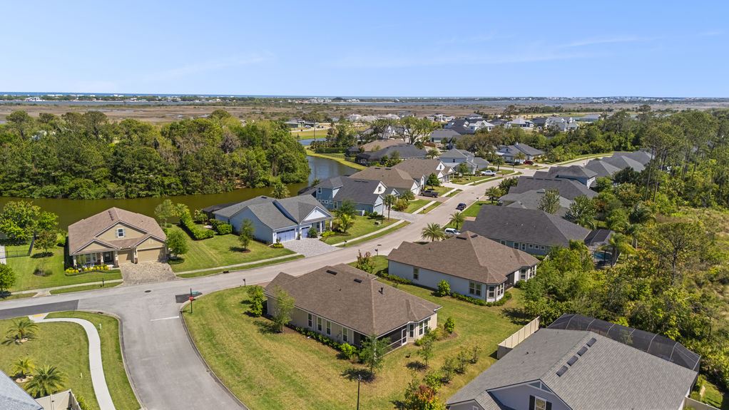 Aerial view showcasing the home’s roofline, 3-car garage, corner lot placement, and surrounding Madeira neighborhood