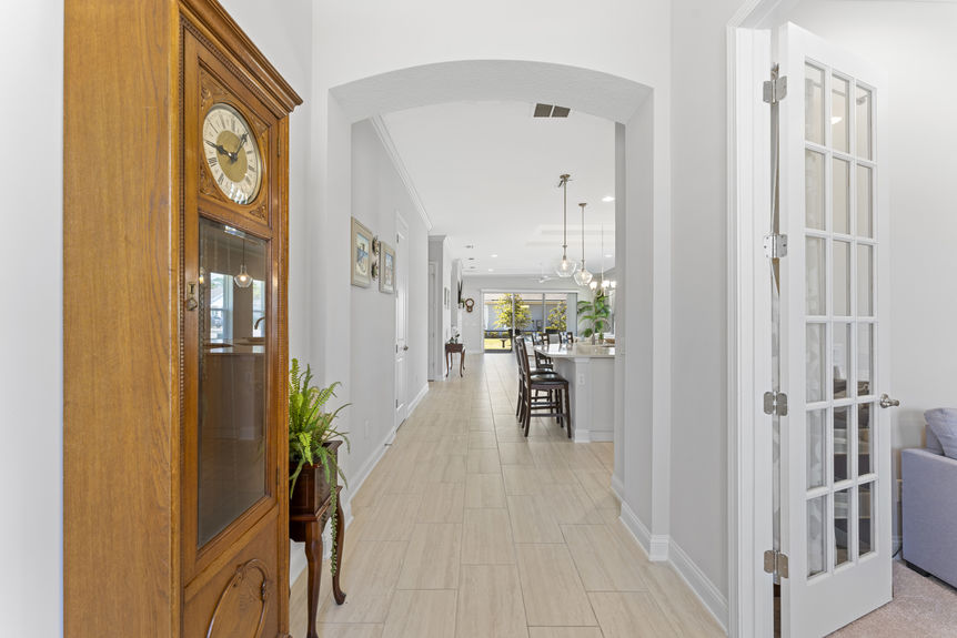 Front entry of Madeira home with stylish door, covered entry, and landscaped walkway