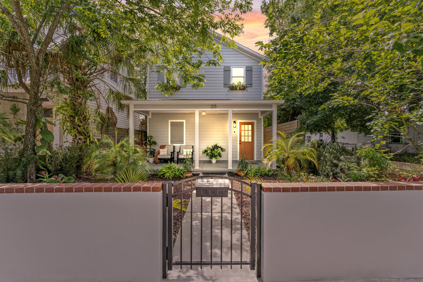 Front exterior of a modern white stilted cottage with a welcoming porch in Lincolnville, St. Augustine