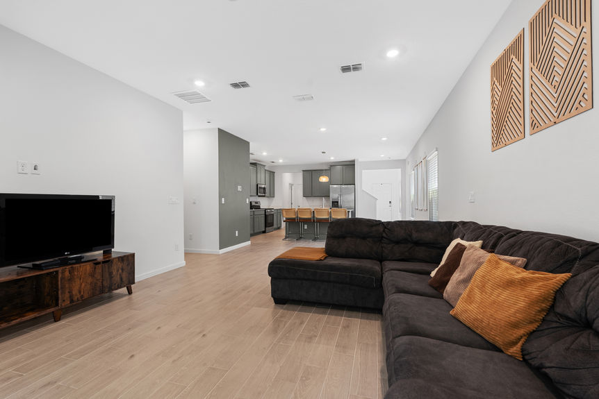 Spacious kitchen with stainless steel appliances, green cabinetry, and view into open living area in a St Augustine home